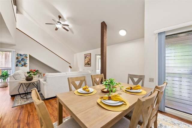 dining space with hardwood / wood-style flooring, high vaulted ceiling, and ceiling fan