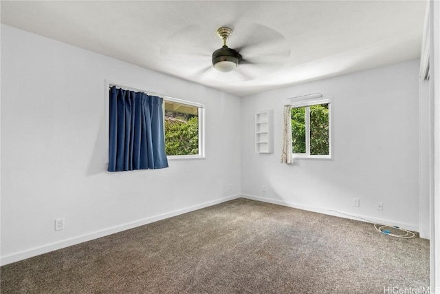 carpeted spare room featuring plenty of natural light and ceiling fan