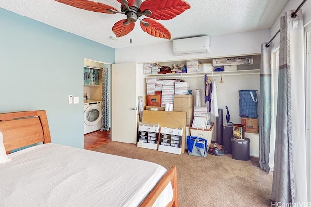 carpeted bedroom with washer / clothes dryer, ceiling fan, a textured ceiling, and a wall unit AC