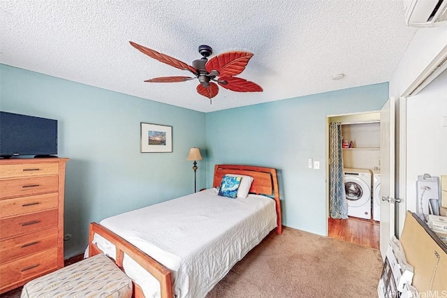 carpeted bedroom featuring a textured ceiling, washing machine and clothes dryer, ceiling fan, and a closet