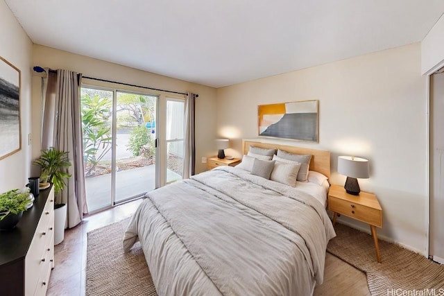 bedroom with wood-type flooring and access to outside