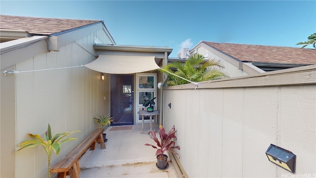 entrance to property featuring a shingled roof