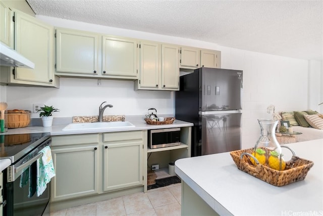 kitchen with light tile patterned floors, a textured ceiling, appliances with stainless steel finishes, and sink