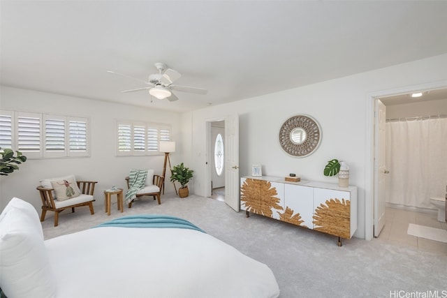 carpeted bedroom with connected bathroom and ceiling fan