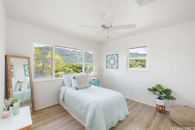 bedroom with visible vents, light wood-type flooring, and ceiling fan