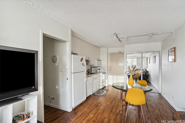 kitchen with white cabinets, a textured ceiling, dark hardwood / wood-style floors, sink, and white appliances