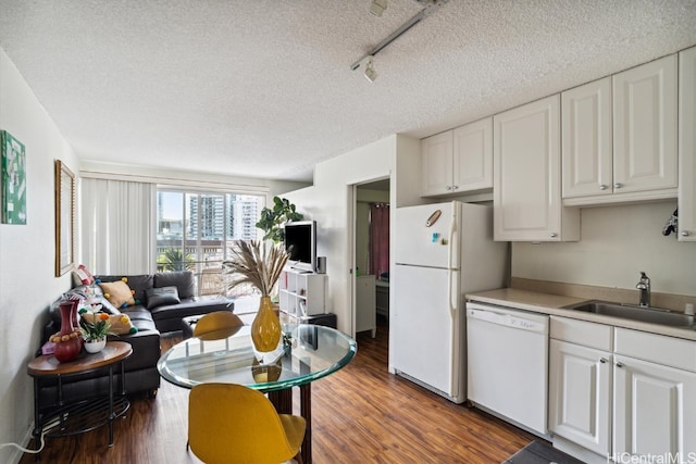 kitchen with sink, white cabinetry, dark hardwood / wood-style floors, and white appliances