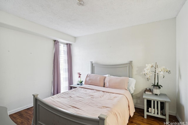 bedroom featuring dark wood-type flooring and a textured ceiling