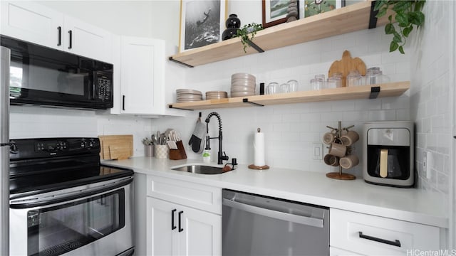 kitchen featuring sink, black appliances, white cabinetry, and backsplash