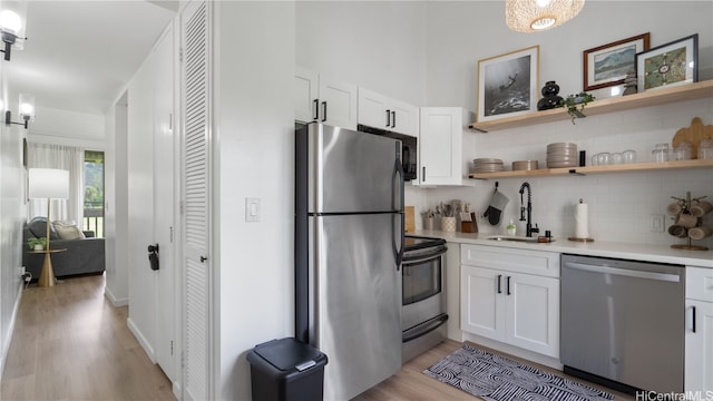 kitchen featuring light hardwood / wood-style floors, stainless steel appliances, sink, and white cabinets