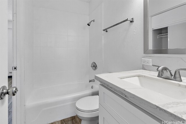 full bathroom with vanity, tiled shower / bath combo, wood-type flooring, and toilet