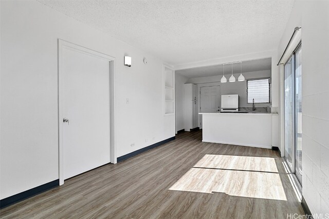 unfurnished living room with hardwood / wood-style floors, a textured ceiling, and sink