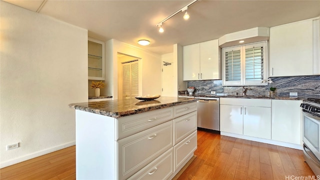 kitchen with sink, decorative backsplash, white cabinets, and light hardwood / wood-style floors