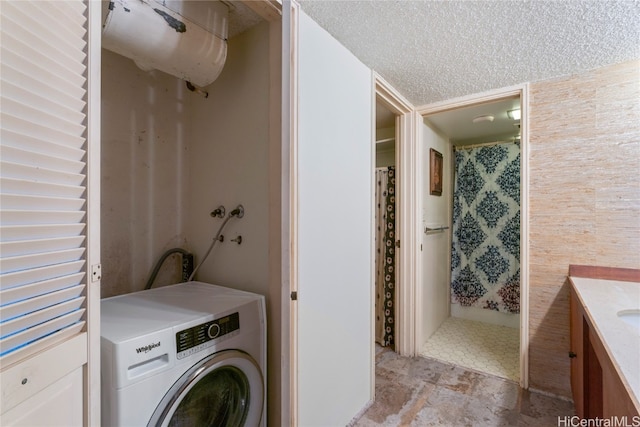 washroom featuring washer / dryer and a textured ceiling