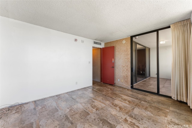 unfurnished room featuring a textured ceiling