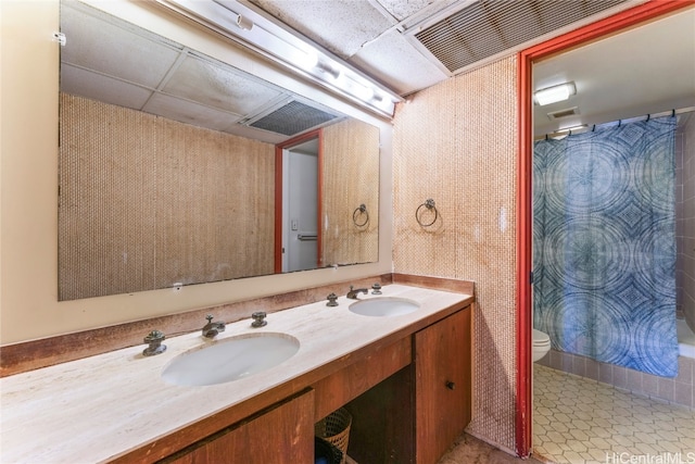 bathroom with vanity, a drop ceiling, a shower with shower curtain, and toilet