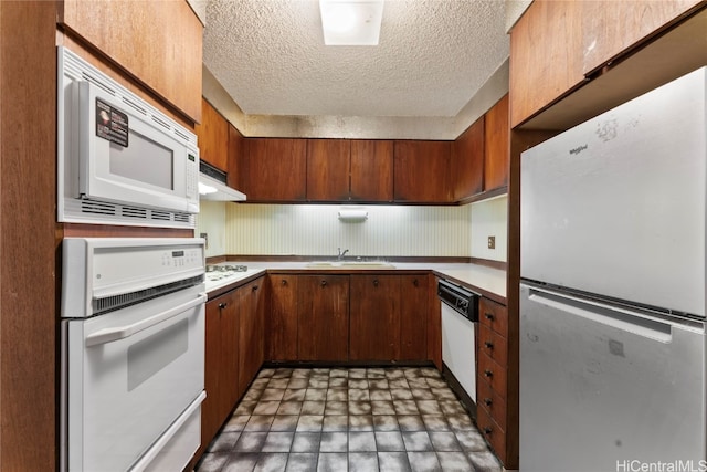 kitchen featuring a textured ceiling, sink, and white appliances