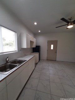 kitchen with white cabinetry, ceiling fan, and sink