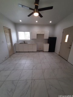 kitchen with white cabinets, sink, and ceiling fan