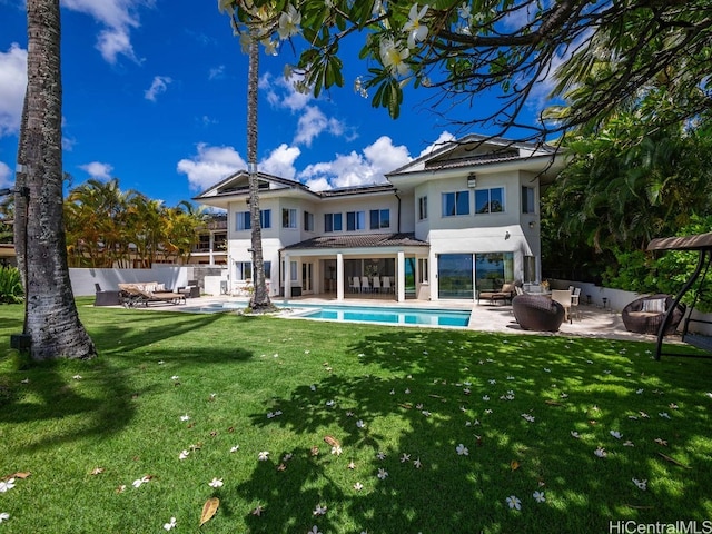 back of house featuring a lawn, outdoor lounge area, a patio area, and a fenced in pool