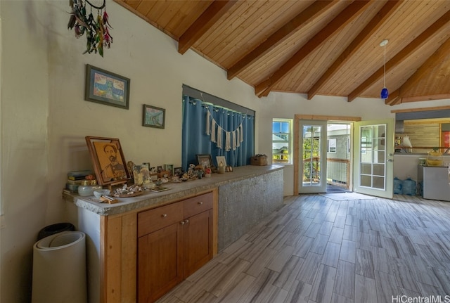 interior space with washer / dryer, lofted ceiling with beams, hanging light fixtures, light hardwood / wood-style floors, and wooden ceiling