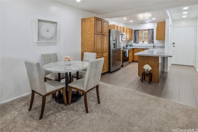 dining room with sink and light colored carpet