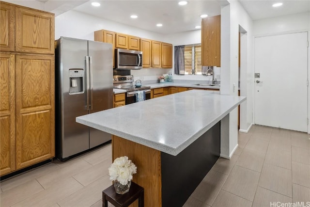 kitchen featuring a breakfast bar, appliances with stainless steel finishes, a kitchen island, and sink