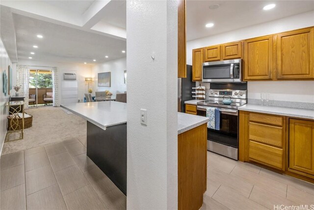 kitchen featuring beam ceiling, an AC wall unit, and appliances with stainless steel finishes