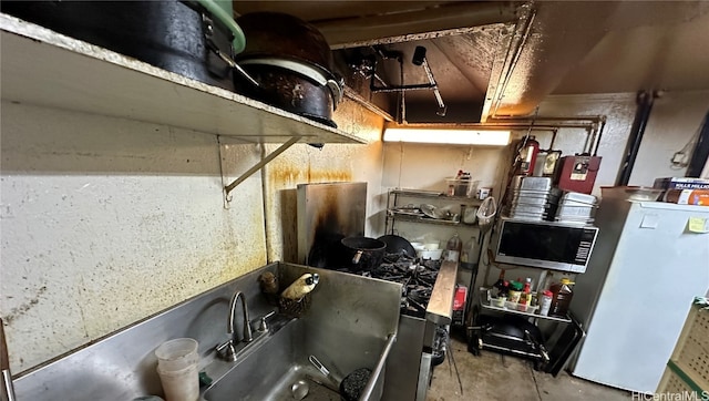 kitchen with concrete floors and white fridge