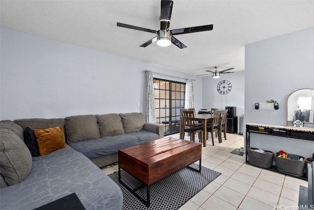 living room featuring a textured ceiling, ceiling fan, and light tile patterned floors