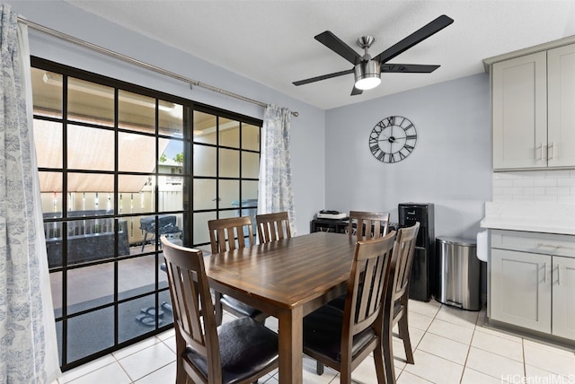 tiled dining room with a textured ceiling and ceiling fan