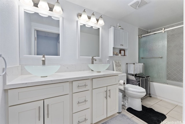 full bathroom with toilet, tiled shower / bath, vanity, and tile patterned floors