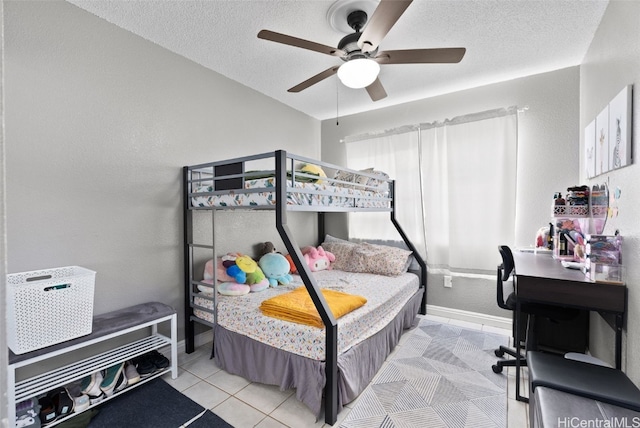 bedroom with a textured ceiling, light tile patterned floors, and ceiling fan