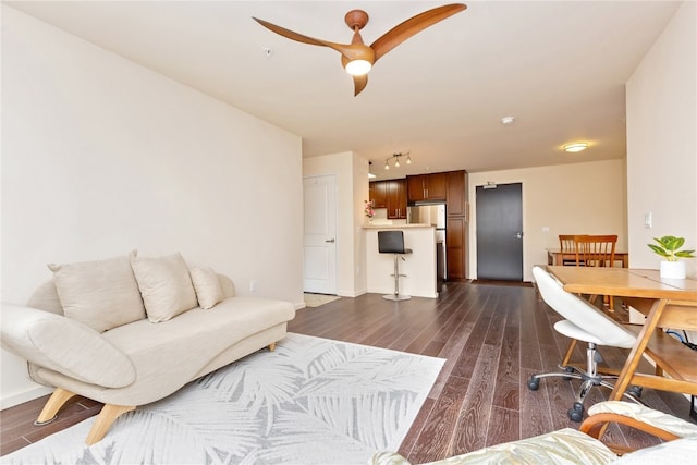 living room featuring ceiling fan and dark hardwood / wood-style flooring