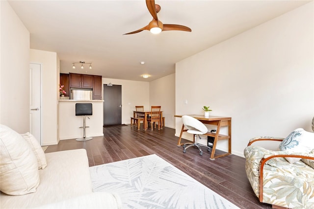 living room featuring dark wood-style flooring, ceiling fan, baseboards, and track lighting