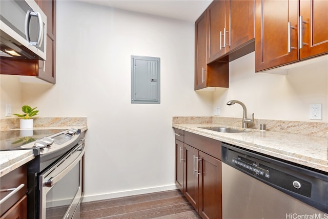 kitchen featuring light stone countertops, sink, stainless steel appliances, electric panel, and dark hardwood / wood-style floors