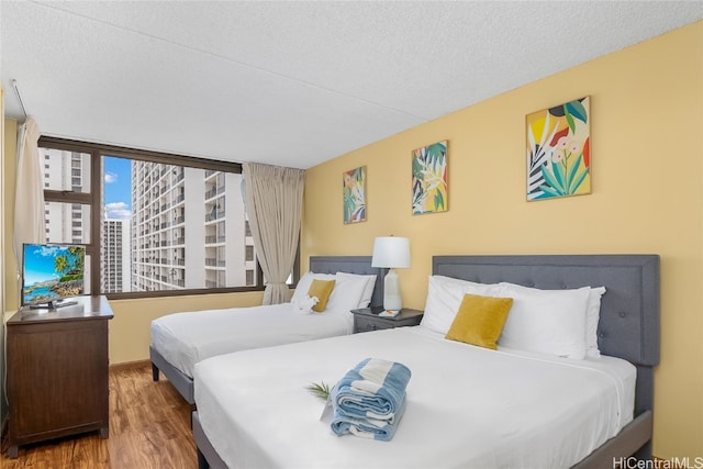 bedroom with a textured ceiling and hardwood / wood-style flooring