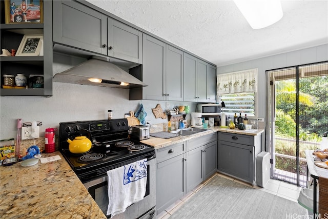 kitchen with light stone countertops, light tile patterned flooring, a textured ceiling, electric range, and gray cabinets