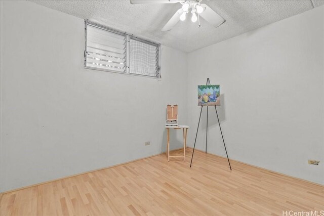 spare room with hardwood / wood-style flooring, ceiling fan, and a textured ceiling