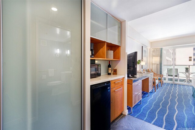 410 Atkinson Dr Unit 932, Honolulu, HI 96814 - kitchen featuring refrigerator, black microwave, brown cabinets, light countertops, and dark tile patterned floors