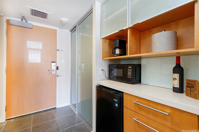 410 Atkinson Dr Unit 932, Honolulu, HI 96814 - kitchen featuring black appliances, open shelves, dark tile patterned floors, light countertops, and brown cabinets