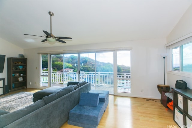 living room with light hardwood / wood-style floors, plenty of natural light, and lofted ceiling