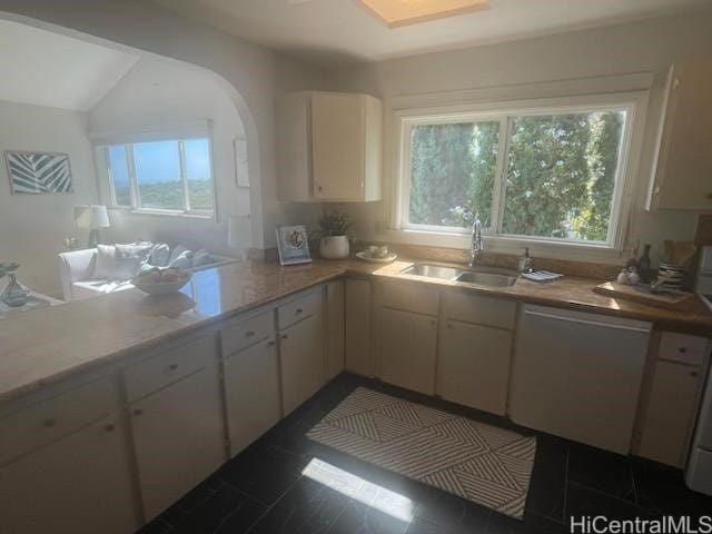 kitchen featuring dark tile patterned floors, sink, dishwasher, white cabinets, and lofted ceiling