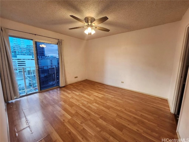 empty room featuring ceiling fan, a textured ceiling, and hardwood / wood-style flooring