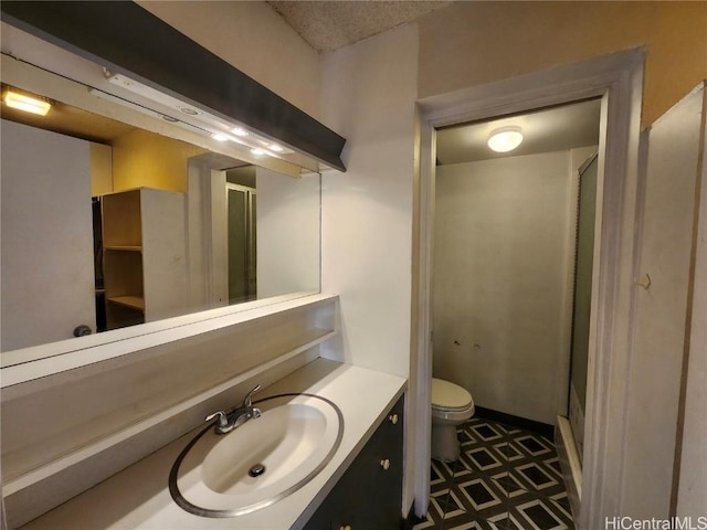 bathroom with vanity, toilet, and a shower with shower door