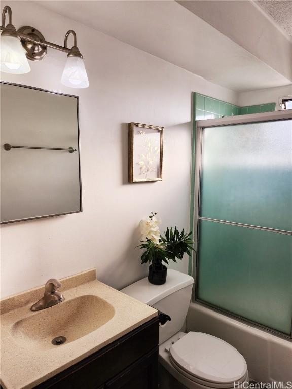 full bathroom featuring vanity, toilet, and bath / shower combo with glass door