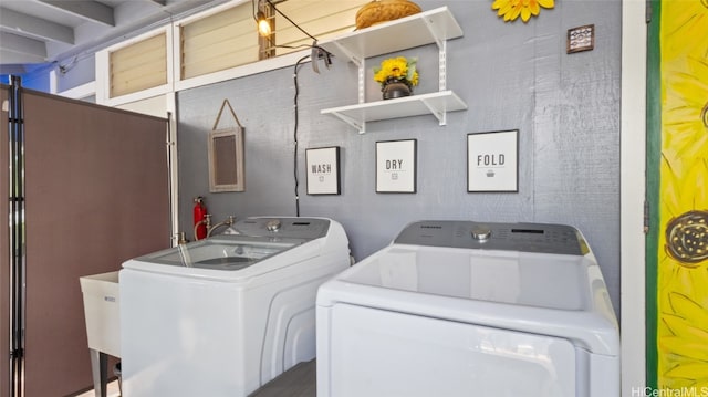 clothes washing area with washing machine and dryer