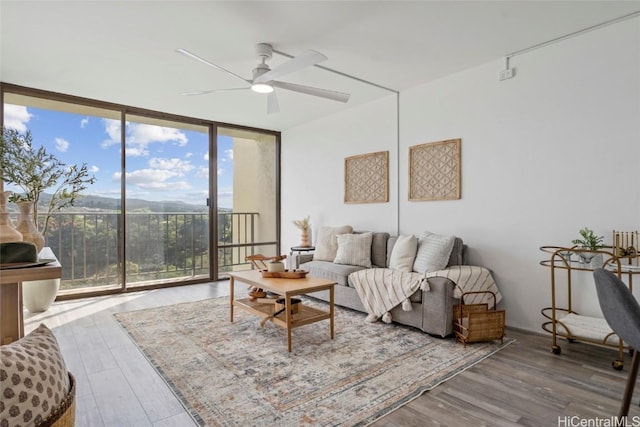 living room with hardwood / wood-style floors, floor to ceiling windows, a healthy amount of sunlight, and ceiling fan