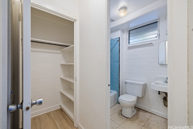 full bathroom featuring toilet, shower / bathing tub combination, hardwood / wood-style floors, and sink