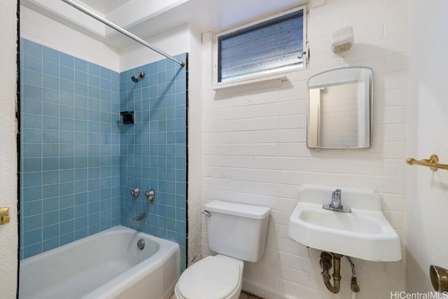 full bathroom with toilet, tiled shower / bath combo, and sink